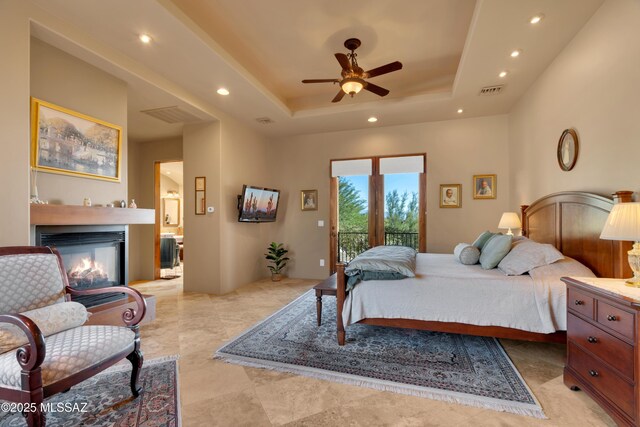 bedroom with access to outside, ceiling fan, and a raised ceiling