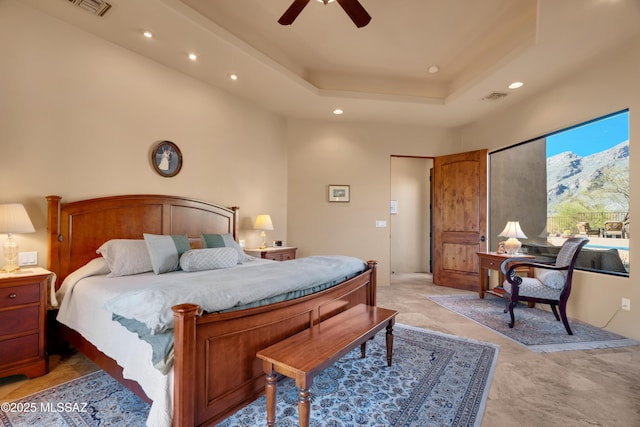 bedroom with ceiling fan and a tray ceiling