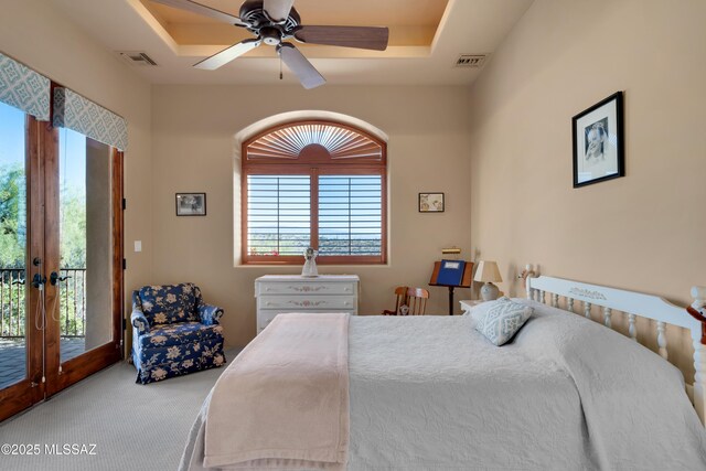 carpeted bedroom with ceiling fan, access to exterior, french doors, and a raised ceiling