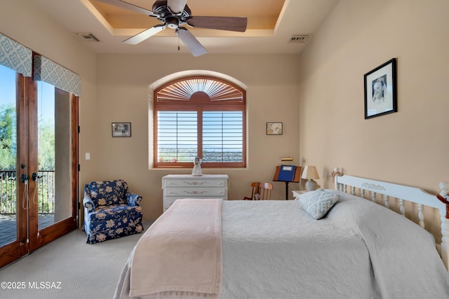 bedroom with french doors, a tray ceiling, ceiling fan, access to exterior, and carpet