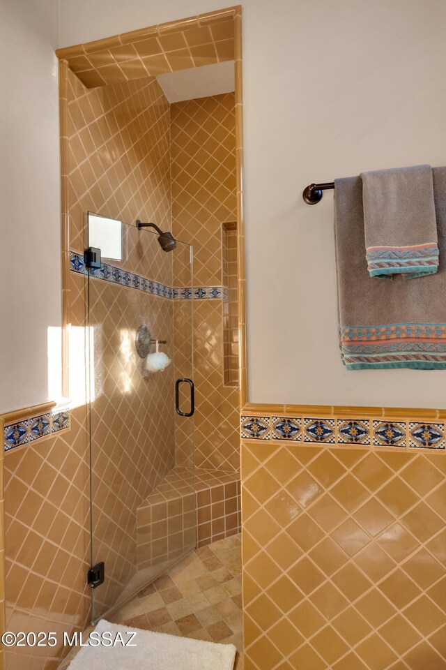 bathroom with walk in shower and tile walls