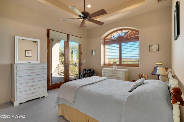 bedroom featuring multiple windows, light colored carpet, access to exterior, and ceiling fan