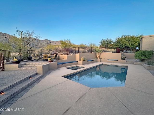 view of pool featuring a jacuzzi, a mountain view, and a patio area