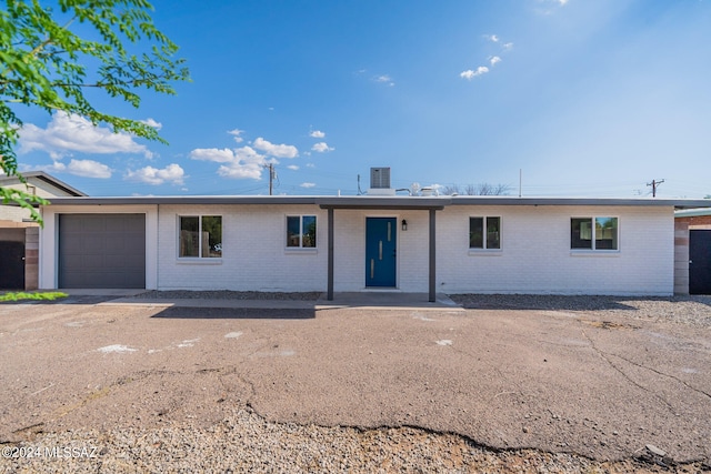 ranch-style home featuring a garage and central AC unit