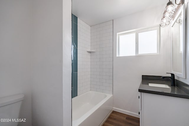 full bathroom featuring hardwood / wood-style flooring, vanity, toilet, and tiled shower / bath