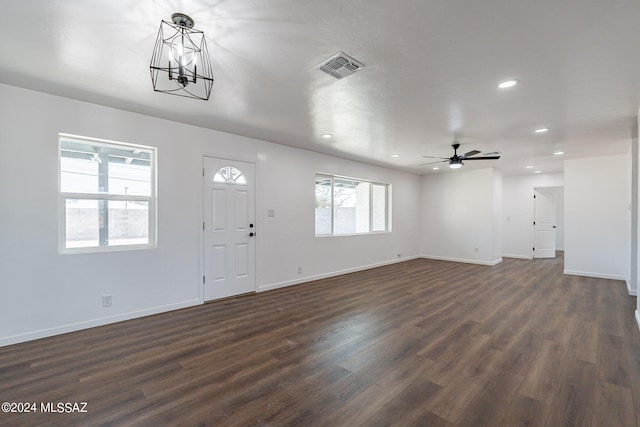 entrance foyer with dark hardwood / wood-style floors and ceiling fan with notable chandelier