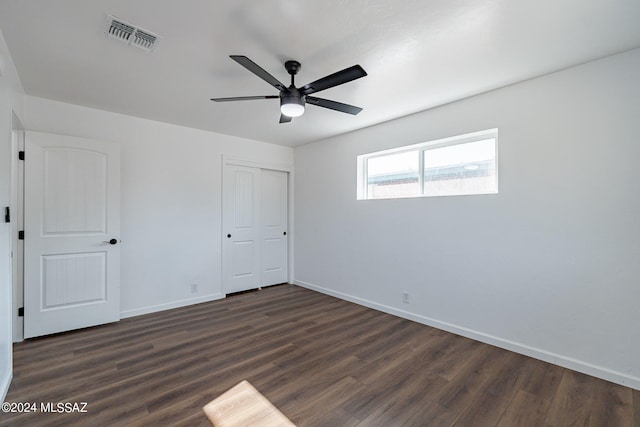 unfurnished bedroom featuring a closet, ceiling fan, and dark wood-type flooring