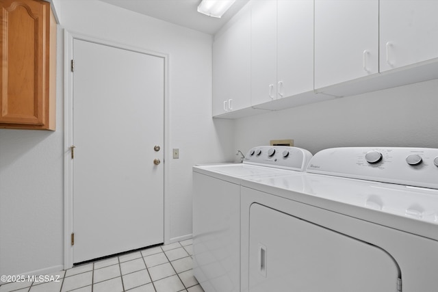 laundry area with cabinets, washer and dryer, and light tile patterned flooring