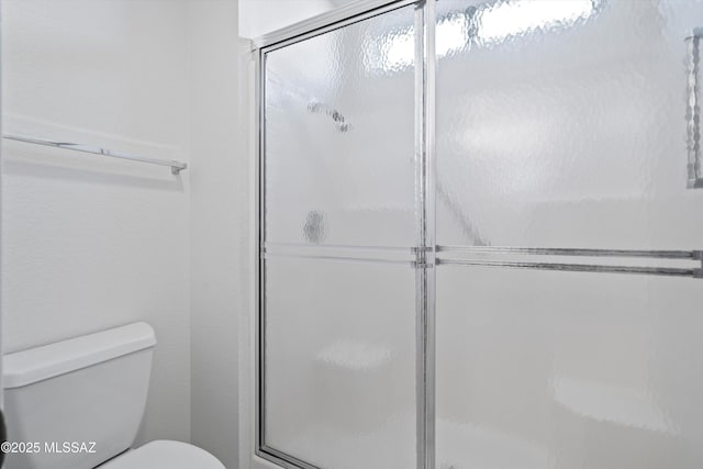 bathroom with an enclosed shower and toilet