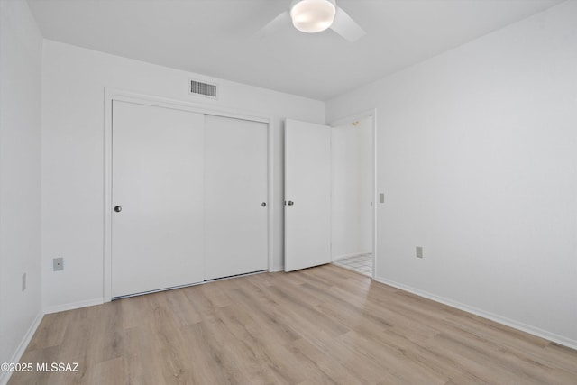 unfurnished bedroom featuring light wood-type flooring, a closet, and ceiling fan