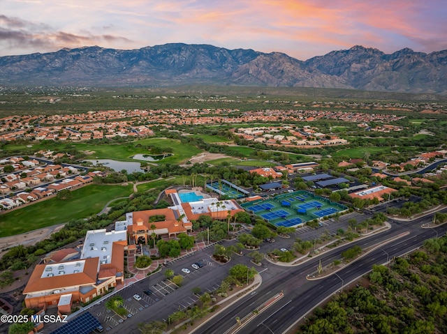 aerial view at dusk featuring a water and mountain view