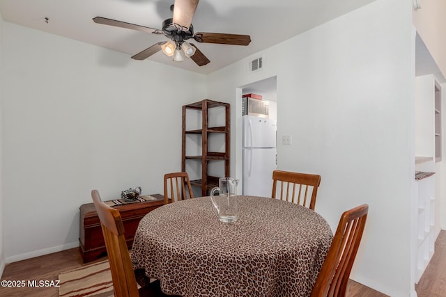 dining room with light hardwood / wood-style floors and ceiling fan