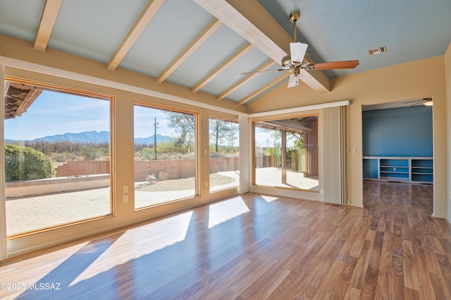 unfurnished sunroom with lofted ceiling with beams, a mountain view, and ceiling fan