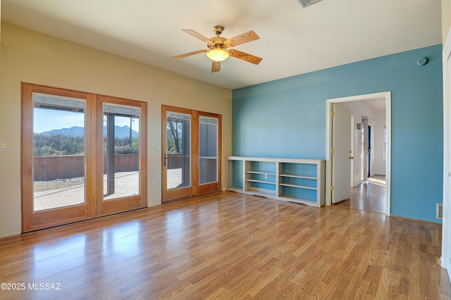 spare room with french doors, ceiling fan, and light hardwood / wood-style flooring