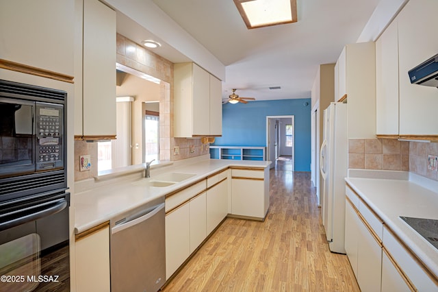 kitchen with sink, black appliances, kitchen peninsula, light hardwood / wood-style floors, and white cabinets