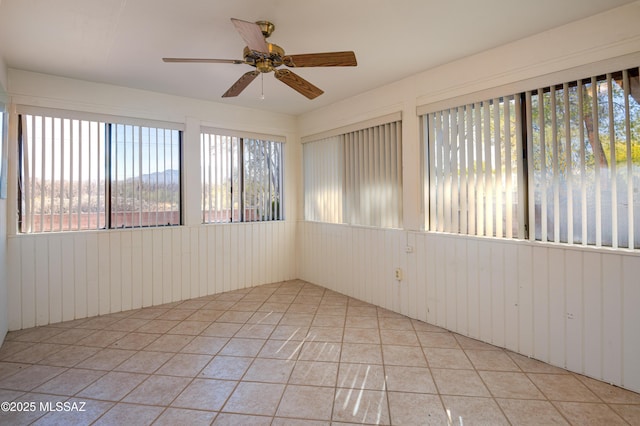 tiled empty room featuring ceiling fan