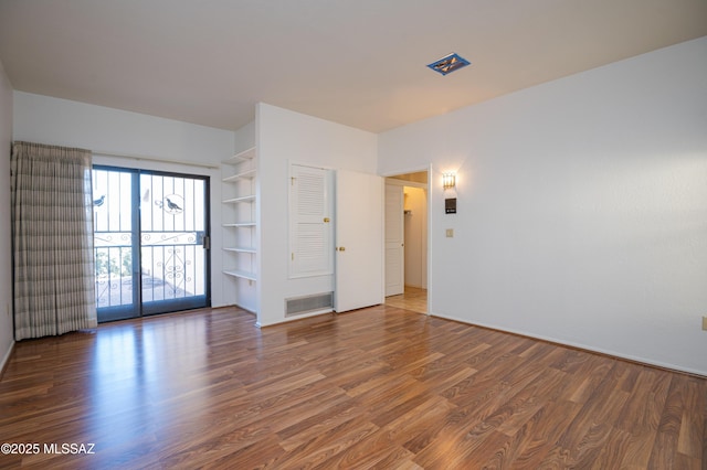 empty room with dark hardwood / wood-style flooring