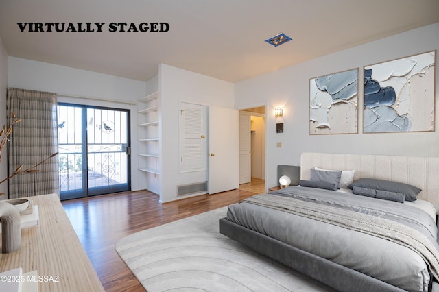 bedroom with access to exterior and wood-type flooring