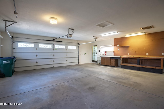 garage with a garage door opener and a workshop area