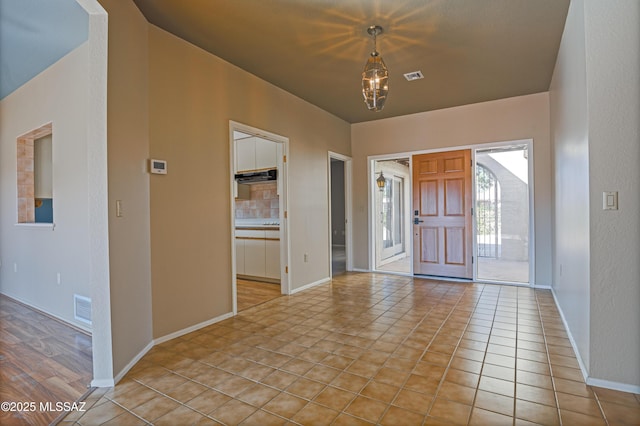 tiled foyer featuring a chandelier