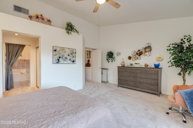 bedroom with ensuite bathroom, ceiling fan, and light colored carpet