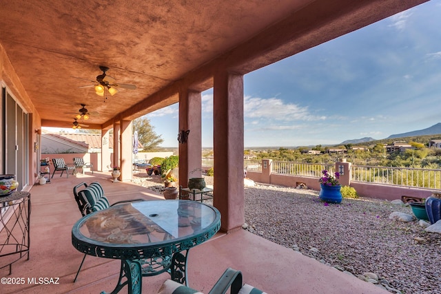 view of patio with ceiling fan and a mountain view