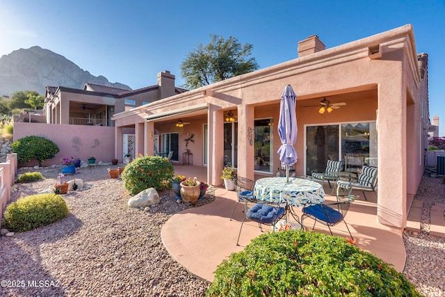 rear view of property with a patio, ceiling fan, and a mountain view