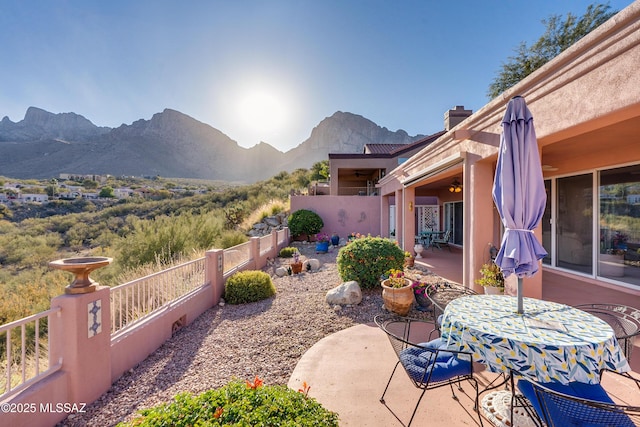 view of patio with ceiling fan and a mountain view