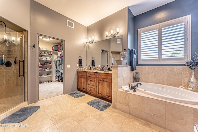 bathroom featuring vanity, tile patterned floors, and plus walk in shower