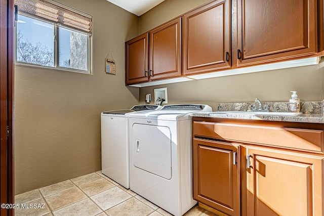 clothes washing area featuring sink, cabinets, light tile patterned floors, and washer and dryer