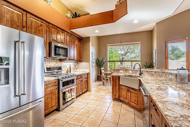 kitchen with sink, backsplash, stainless steel appliances, light stone countertops, and light tile patterned flooring