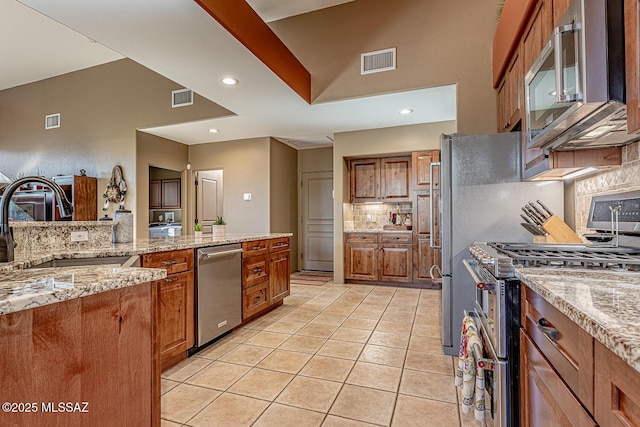 kitchen featuring light stone countertops, light tile patterned floors, stainless steel appliances, and sink