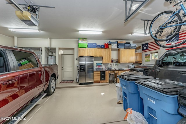 garage with water heater, a garage door opener, and stainless steel fridge