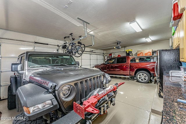 garage with a garage door opener and stainless steel fridge