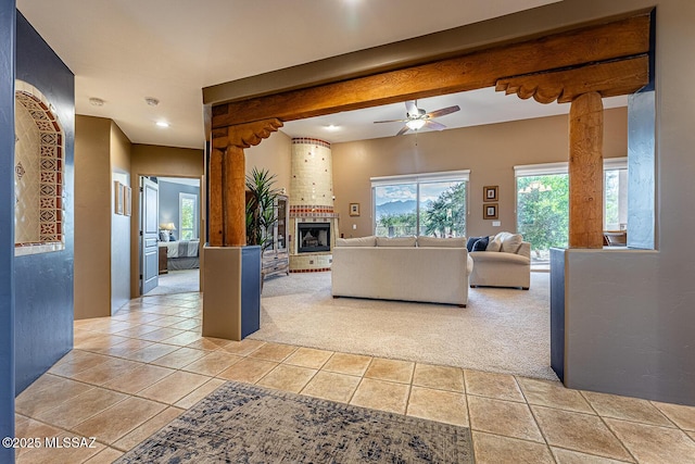 living room with ceiling fan, beam ceiling, and light carpet