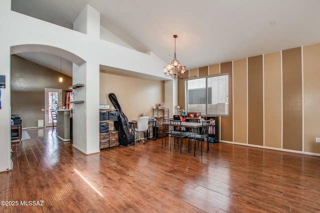 dining space featuring vaulted ceiling, hardwood / wood-style floors, and a notable chandelier