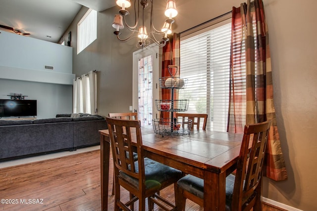 dining room with hardwood / wood-style flooring, a wealth of natural light, and a chandelier