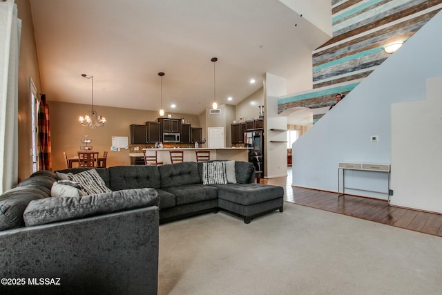 living room with light hardwood / wood-style floors, a chandelier, and high vaulted ceiling