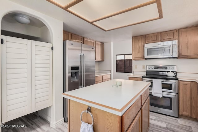 kitchen with a kitchen island, stainless steel appliances, and light hardwood / wood-style flooring