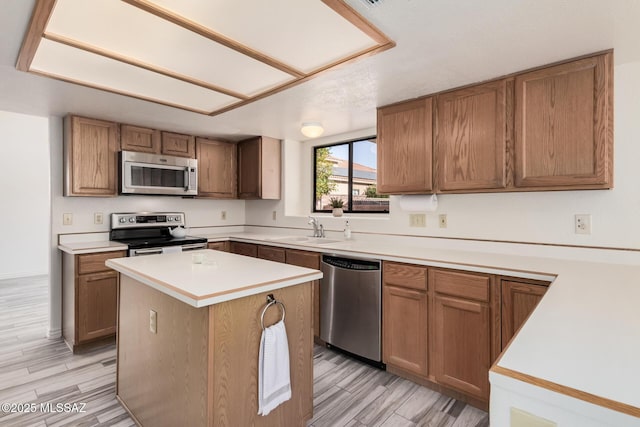 kitchen with sink, a center island, stainless steel appliances, and light hardwood / wood-style floors