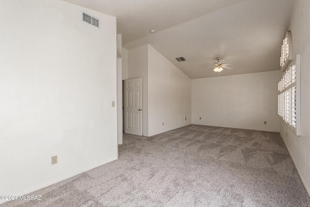 spare room featuring carpet, ceiling fan, and vaulted ceiling