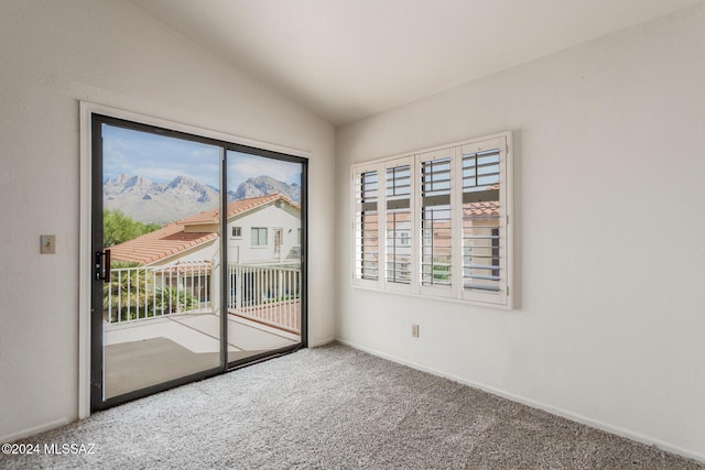 carpeted spare room with a mountain view and vaulted ceiling