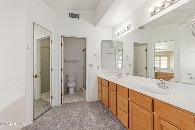 bathroom featuring a bath, vanity, toilet, and lofted ceiling