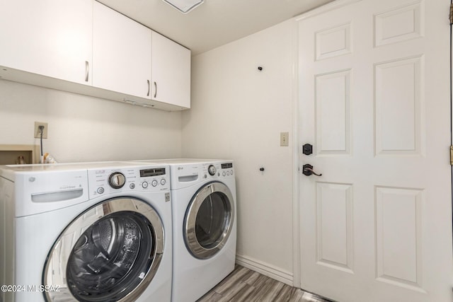 laundry room featuring light hardwood / wood-style floors, cabinets, and independent washer and dryer