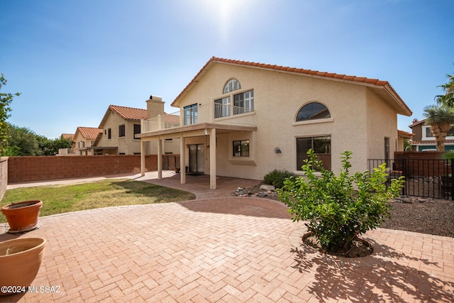 back of property featuring a balcony and a patio