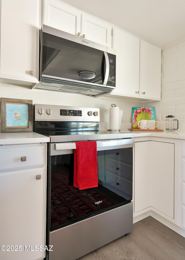 kitchen featuring white cabinetry, light wood-type flooring, and appliances with stainless steel finishes