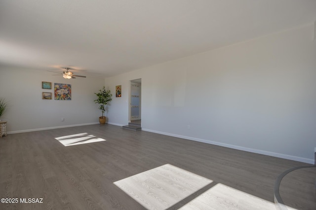 empty room featuring ceiling fan and dark wood-type flooring