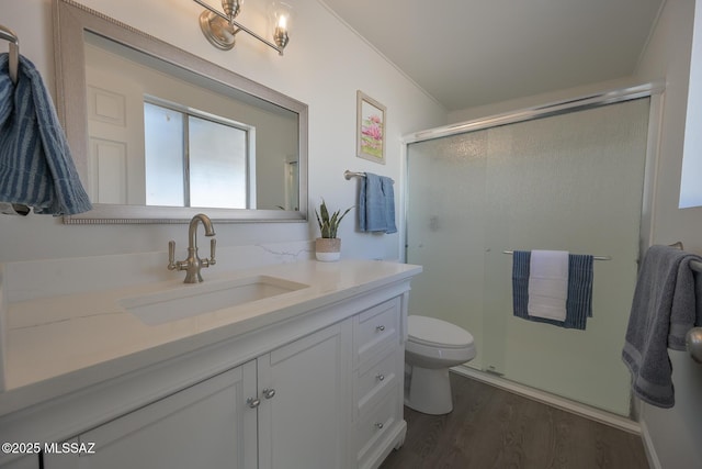 bathroom featuring toilet, an enclosed shower, vanity, and hardwood / wood-style floors