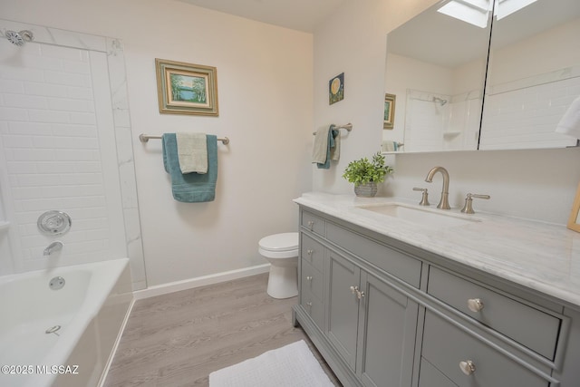 full bathroom with toilet, wood-type flooring, a skylight,  shower combination, and vanity