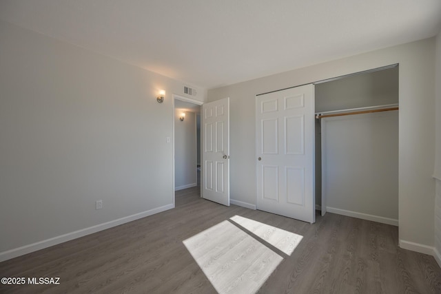 unfurnished bedroom with hardwood / wood-style floors and a closet